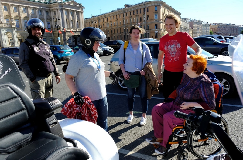 На фото: Марина Козикова подъезжает на инвалидной коляске к мотоциклистам и своим коллегам на Синем мосту