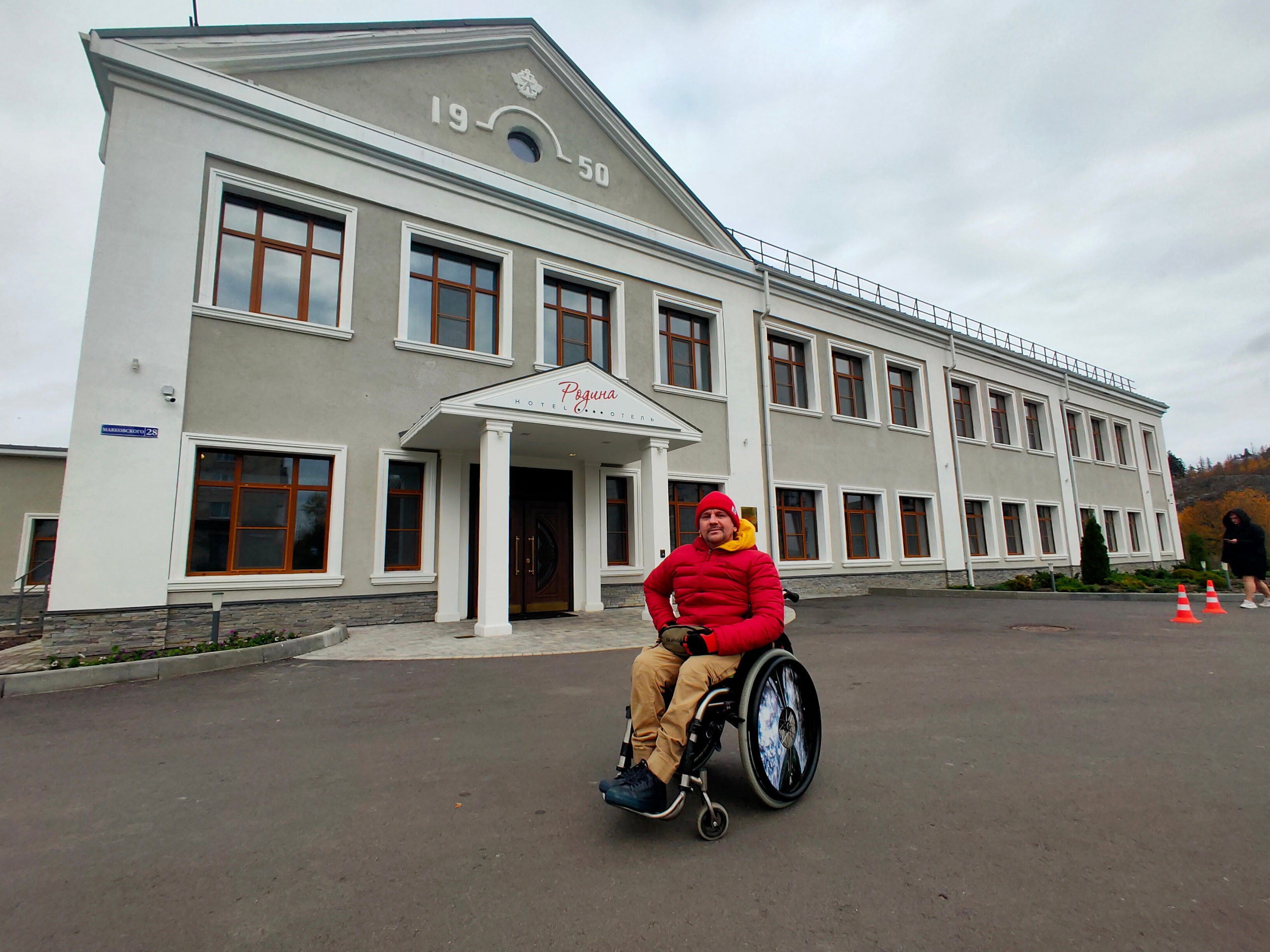 На фото: Владимир Рудак на коляске перед зданием гостиницы Родина