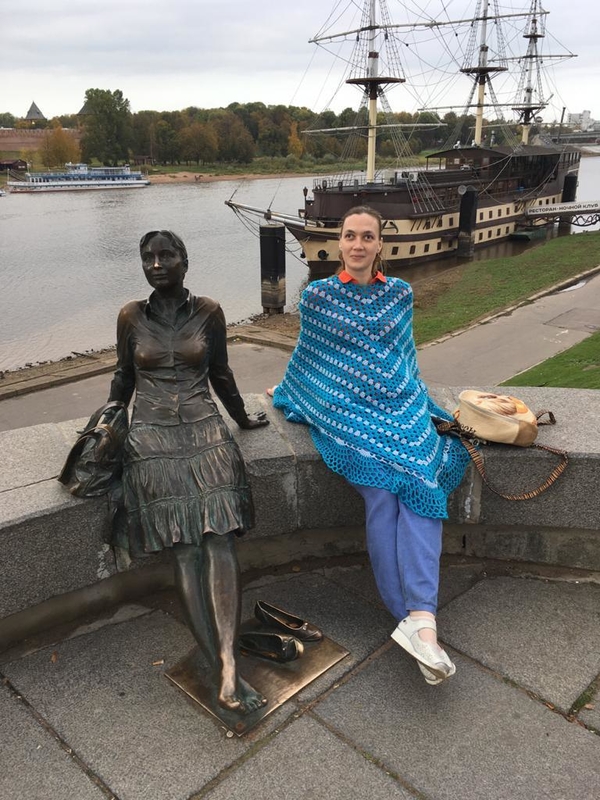 На фото: Евгения Малышко у Пешеходного моста сидит на парапете рядом с бронзовым памятником девушке-туристке, копируя ее позу