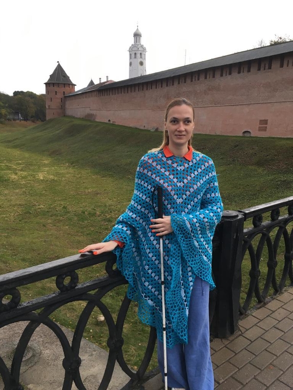 На фото: Евгения Малышко возле Новгородского Кремля стоит на мосту, ведущем ко входу, опираясь рукой на ажурное ограждение