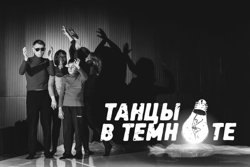 На фото: группа людей на сцене, замерших в различных позах. Черно-белая фотография. Надпись на фото: "Танцы в темноте"