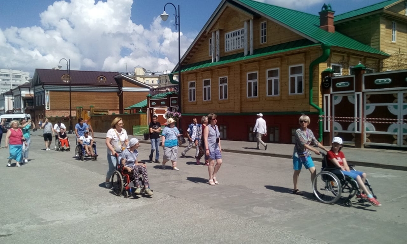 На фото: экскурсионная группа туристов на инвалидных колясках на экскурсии по городу 