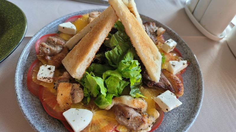 На фото: мясной салат с гренками на тарелке 