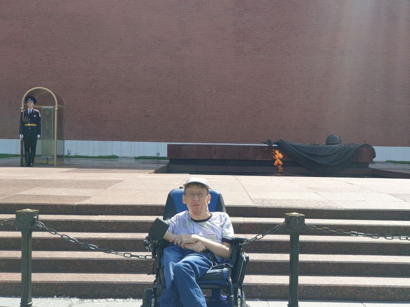 На фото: Максим Аркуша на электроколяске перед вечным огнем на Красной площади в Москве