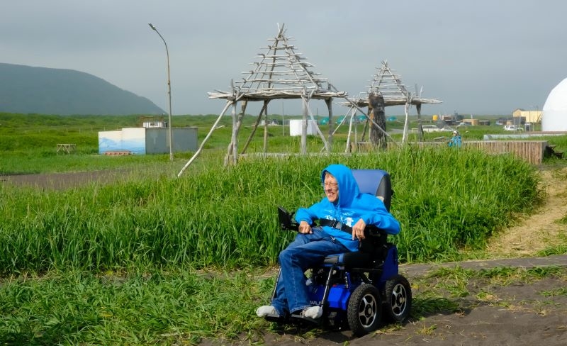 На фото: Максим Аркуша на электроколяске спускается с травянистого склона на пляж