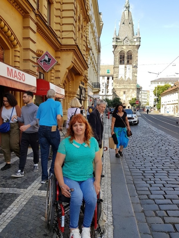 На фото: Марина Ларионова на инвалидной коляске на тротуаре в центре Праге