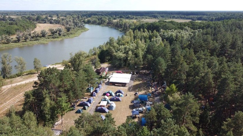 На фото: вид на палаточный лагерь, разбитый на берегу реки, с высоты