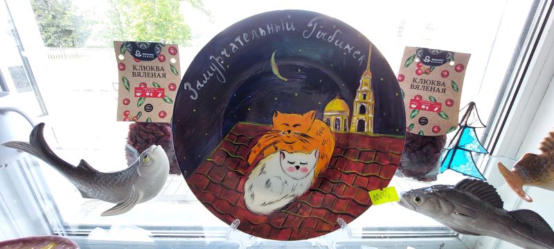 На фото: сувенир  - круглый магнитик с двумя нарисованными спящими котами и надписью: Замурчательный Рыбинск