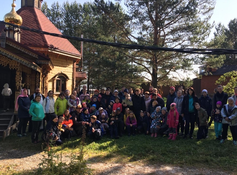 На фото: общая фотография участников похода возле небольшой деревянной церкви