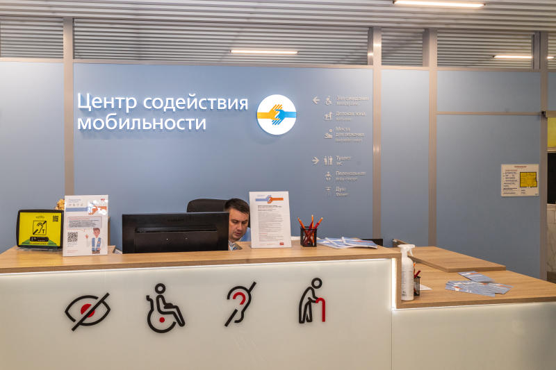 На фото: сотрудник центра содействия мобильности РЖД сидит за стойкой в зале ожидания для маломобильных пассажиров на Казанском вокзале в Москве