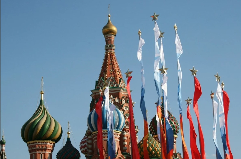 На фото: флаги триколор, украшенные звездами, развеваются на ветру на Красной площади в Москве