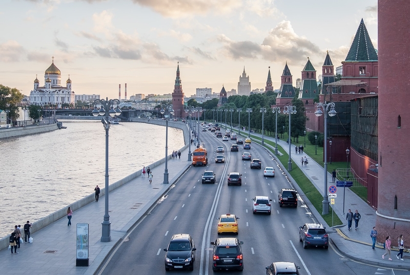 На фото: машины едут по четырехполосному движению вдоль Москва-реки и стен Кремля на закате. Впереди возвышается Храм Христа Спасителя