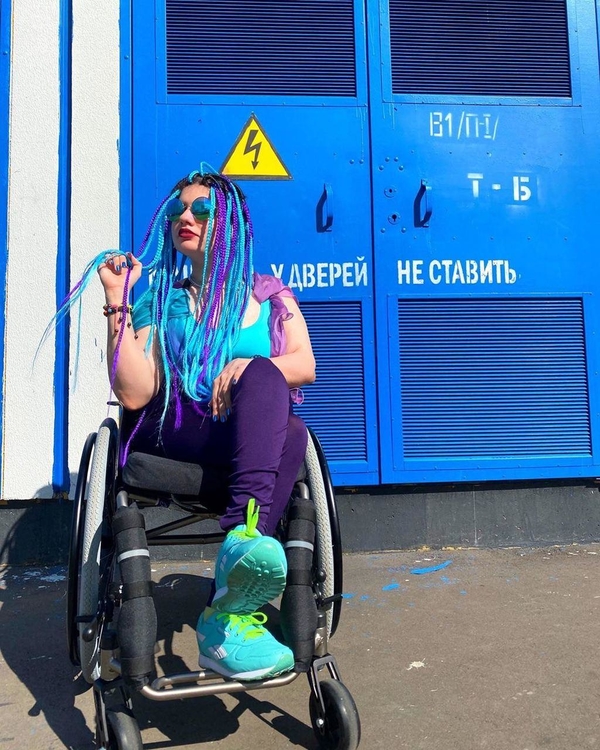 На фото: Дарья Павлова сидит в инвалидной коляске возле кирпичного здания